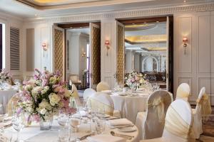 a dining room with white tables and chairs and flowers at lebua at State Tower in Bangkok +37 photos