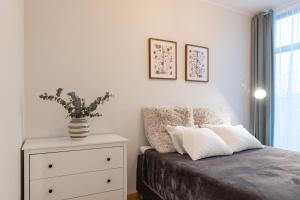 タルトゥにあるCozy Riia kvartal apartment with free parking and air conditioningのベッドルーム1室(ベッド1台、植物付きドレッサー付)