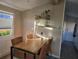 a dining room with a wooden table and chairs at Langewieke in Hollum