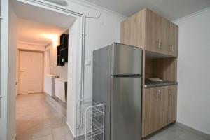 a kitchen with a stainless steel refrigerator and wooden cabinets at Stelios Home in Nea Vrasna