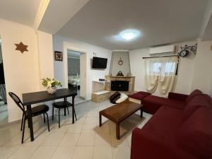 a living room with a red couch and a table at Stelios Home in Nea Vrasna