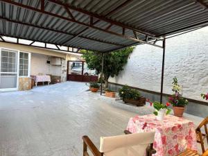 a patio with awning and a table and chairs at Stelios Home in Nea Vrasna