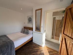 a bedroom with a bed and a large window at The Stables - Deer Park Farm in Solihull