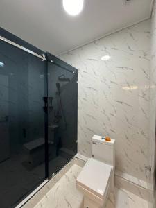 een badkamer met een douche, een toilet en een glazen douchecabine bij Аpartment in Samarkand
