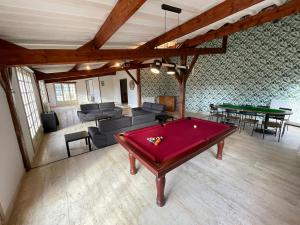 a living room with a red pool table in it at Villa 21 couchages avec piscine interieure chauffée in Belleu