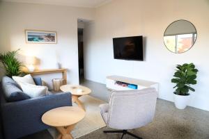 a living room with a couch and a chair and a mirror at Ellen City Centre in Fremantle