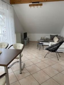 a living room with chairs and a table and a couch at Ferienwohnung Blumenfeld in Gengenbach +19 photos