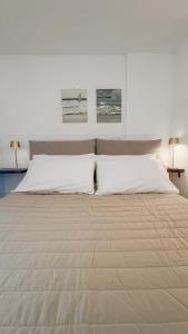 a large bed with two white pillows on it at Wanda Mtb Paradise Home in Finale Ligure