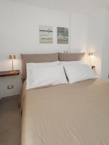a bedroom with a large bed with white sheets and two lamps at Wanda Mtb Paradise Home in Finale Ligure +51 photos
