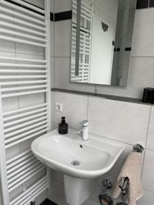 a bathroom with a white sink and a mirror at Ferienwohnung Blumenfeld in Gengenbach