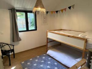 a bedroom with a bunk bed and a window at Les lodges de Marie Chalet 3 in Banassac +3 photos