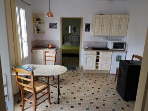a kitchen with a table and chairs and a table and a kitchen at La maisonnette - 5 min Gare - Parking Facile - Netflix in Évreux
