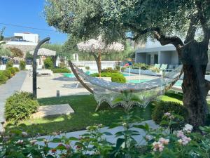 波托什Thassos OLIVIA RESORT的房屋旁花园的吊床