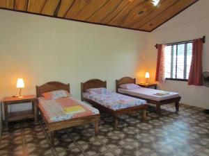 una camera con due letti e due tavoli e una finestra di riverfront guest house a Sablayan