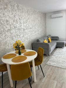 ein Wohnzimmer mit Tisch und Stühlen und einer Couch in der Unterkunft Green Heaven in Târgu Mureș