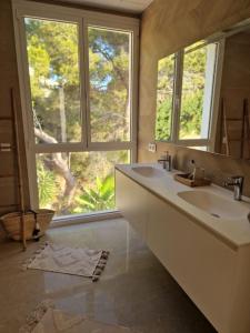 a bathroom with two sinks and a large window at Noahs Paradise in Benissa