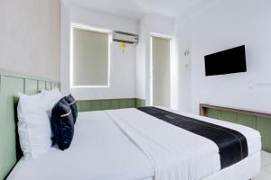 ジョグジャカルタにあるCollection O Yogyakarta Near Tugu Jogja Formerly Vivo Aparmentのベッドルーム(白いベッド1台、テレビ付)
