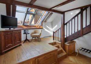 a living room with a tv and a staircase at Charles Bridge Palace in Prague