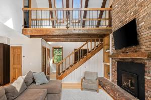 a living room with a couch and a fireplace at Spacious Mountain Retreat set on 7 acres & Pond in Stowe