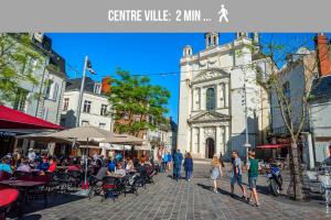 a group of people walking down a street in front of a building at Le Avena - Centre Ville - Calme - Cour in Saumur