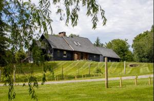 an old house on a hill with a grass field at Spacious Mountain Retreat set on 7 acres & Pond in Stowe