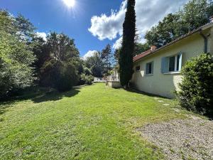 ein Hinterhof eines Hauses mit einem Rasen in der Unterkunft Villa en pleine nature avec piscine privée - 8 couchages - 4 chambres - Proche St Antonin Noble Val in Penne