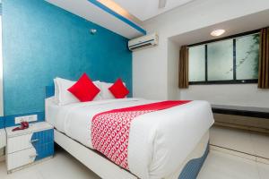 孟买Collection O Grand Corp Inn的卧室里有一张大床，配有红色枕头