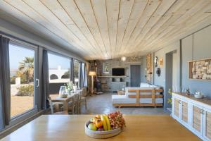 a kitchen and living room with a table with a bowl of fruit at Vitamine Sea House - Island Living Paros in Parasporos
