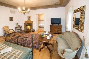 a living room with a couch and a table and a television at Chateau GrandCastle in Liptovský Hrádok