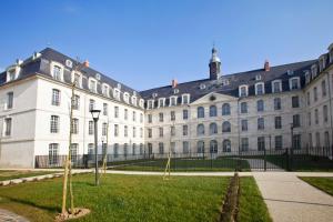 un grand bâtiment blanc avec une pelouse devant lui dans l'établissement Odalys City Amiens Blamont, à Amiens