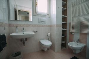 ein Badezimmer mit Waschbecken, Toilette und Spiegel in der Unterkunft Family Apartment Vista Lago in Stresa + 51 Fotos