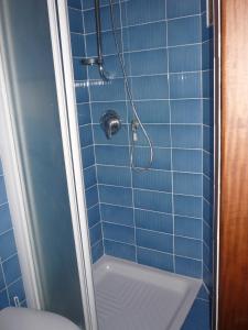 y baño de azulejos azules con ducha y aseo. en Affittacamere Andronaco, en Milán