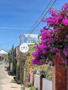 Um ramo de flores roxas pendurado numa cerca. em NOMAD Home & Coffee em Da Lat mais 49 fotografias