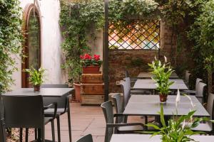 an outdoor patio with tables and chairs and plants at iH Hotels Venezia Salute Palace in Venice