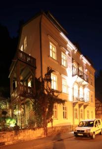 una furgoneta blanca estacionada frente a un gran edificio en Apartmenthaus Saxonia en Bad Schandau