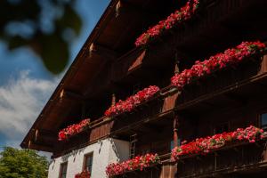 un edificio con gerani rossi su un lato di esso di Hotel Zur Post ad Alpbach