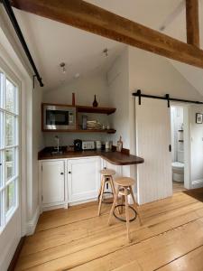 a kitchen with a table and two stools in it at The Parcel Shed Gilling East in Gilling East