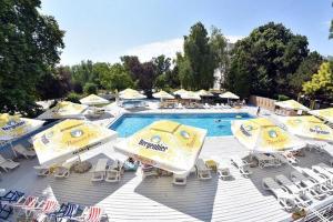 a group of umbrellas and chairs next to a swimming pool at Hotel Miorita Neptun in Neptun