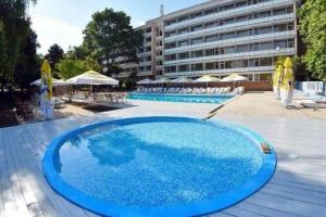 a large blue swimming pool in front of a building at Hotel Miorita Neptun in Neptun