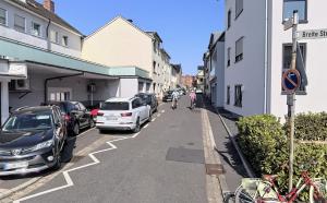 a person riding a bike down a street with parked cars at Business & Family - Zentral, 24h Check-In, XXL TV in Siegburg