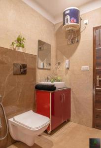 a bathroom with a toilet and a sink at The Cloudberry Kasauli I Guaranteed Best Price I Serviced Villa I Open Air Rooftop I Couple Friendly I Pvt Balcony I Kasauli By ExoticStays in Kasauli