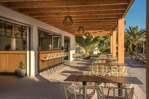 a patio with tables and chairs and a restaurant at Malena Hotel & Suites - Adults Only by Omilos Hotels in Amoudara Herakliou +37 photos
