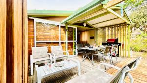 un patio con tavolo, sedie e un pianoforte di Chalet M tout confort proche des plages a Pianottoli-Caldarello