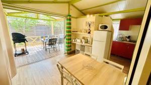 una cucina con tavolo e una sala da pranzo di Chalet M tout confort proche des plages a Pianottoli-Caldarello