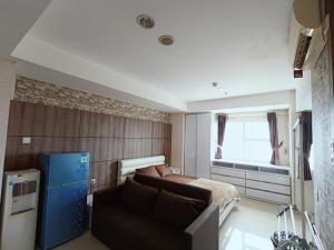 a bedroom with a bed and a couch and a window at Chiens168 in Cikarang