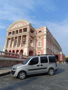 un furgone bianco parcheggiato di fronte a un edificio di Receptivos Manaus a Manaus