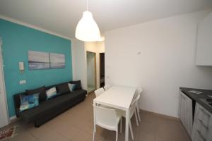 a living room with a black couch and a white table at Residence Verdena appartamento 02 in Rosolina Mare +19 photos