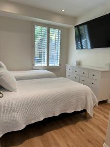 a bedroom with two beds and a flat screen tv at Irvine Gem Luxury condo near Irvine Business & UCI Hospital in Irvine