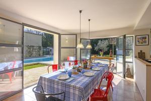 a dining room with a table with red chairs at Mas du Micocoulier in Paradou