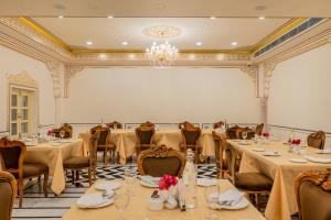 a banquet room with tables and chairs and a chandelier at Brij Castle in Jaipur